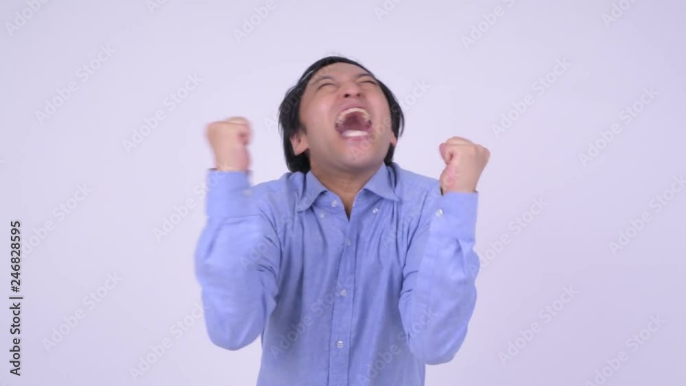 Happy Japanese businessman looking excited with fists raised Happy Japanese businessman looking excited with fists raised