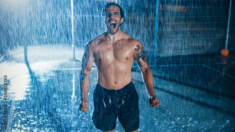 Strong Muscular Fit Shirtless Young Man Shouting after His Athletic  Exercises. He is Cheering at Night in Heavy Rain with One Light Behind Him.  Stock Photo | Adobe Stock