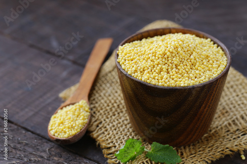 millet groats in a wooden cup, healthy food