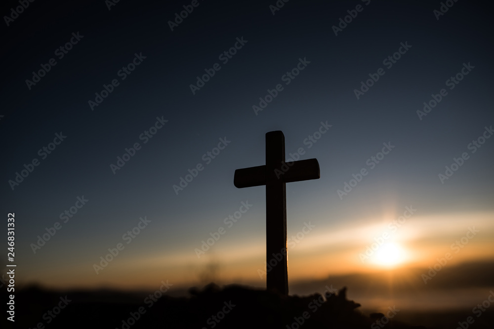 Silhouette of catholic cross and sunrise