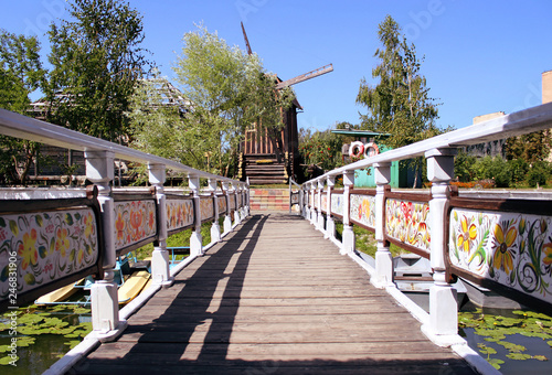 The bridge over the river with a beautiful railing that leads to the old windmill. photo