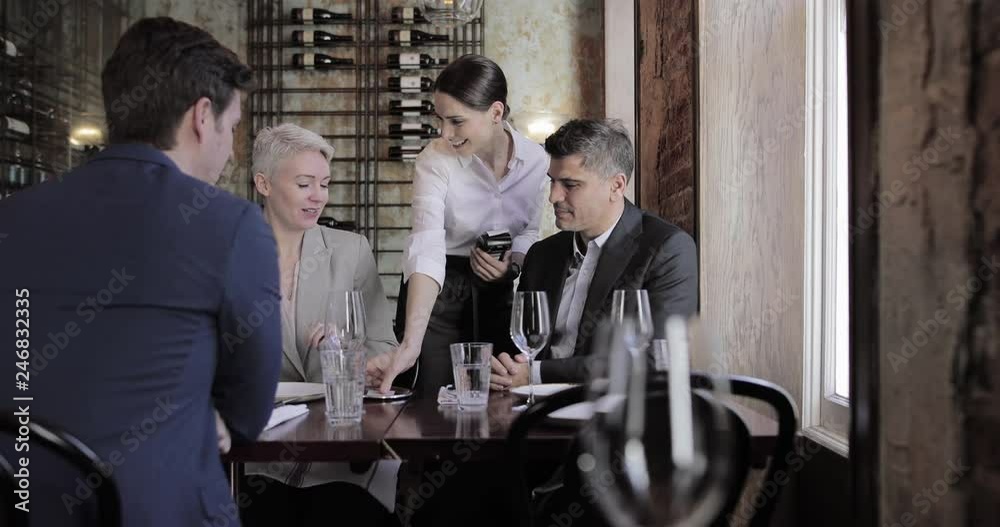 Businesswoman paying for a meal in a restaurant Businesswoman paying for a meal in a restaurant