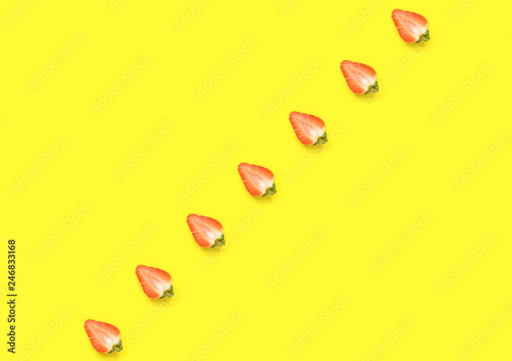 Ripe juicy strawberries cut in half arranged in diagonal on bright yellow background. Creative minimalist flat lay. Vitamins vegan healthy diet concept. Poster placeholder mockup template Ripe juicy strawberries cut in half arranged in diagonal on bright yellow background. Creative minimalist flat lay. Vitamins vegan healthy diet concept. Poster placeholder mockup template