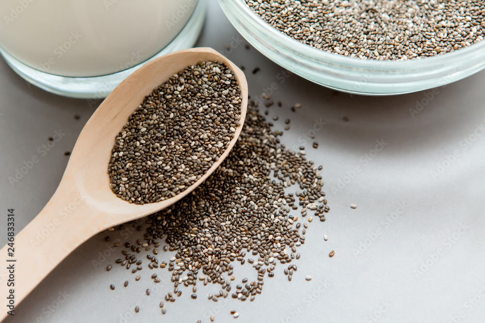 Chia seeds in wooden spoon on grey background.copy spase.Chia seeds in wooden spoon, lying on dark stone background Chia seeds in wooden spoon on grey background.copy spase.Chia seeds in wooden spoon, lying on dark stone background