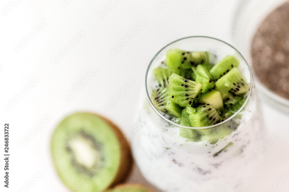 Stockfoto pudding of kefir Chia and kiwi seeds in a glass on a light  background horizontally.Portion of natural yogurt with chia seed and kiwi  slices in a jar for a breakfast.copy spase
