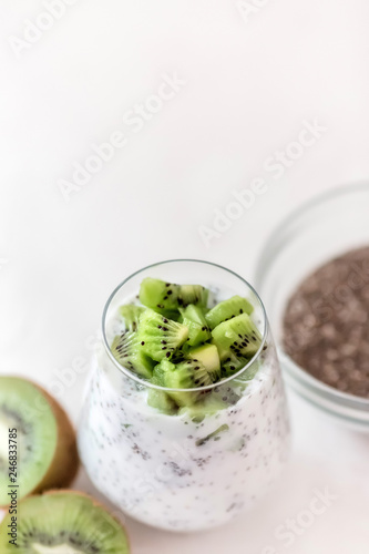pudding of kefir Chia and kiwi seeds in a glass on a light background horizontally.Portion of natural yogurt with chia seed and kiwi slices in a jar for a breakfast.copy spase