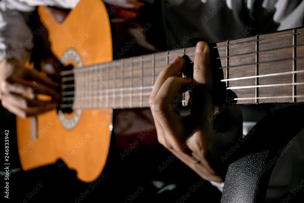Fototapeta premium Guitarist hands and guitar close up. Playing classic guitar. Play the guitar.