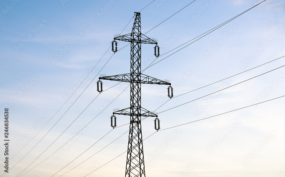 Low angle view of electricity pylon against blue sky at sunset Low angle view of electricity pylon against blue sky at sunset