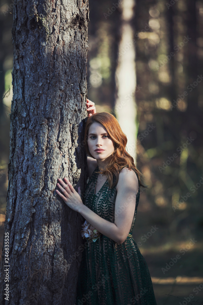 beautiful young redhead woman in green dress in the forest beautiful young redhead woman in green dress in the forest