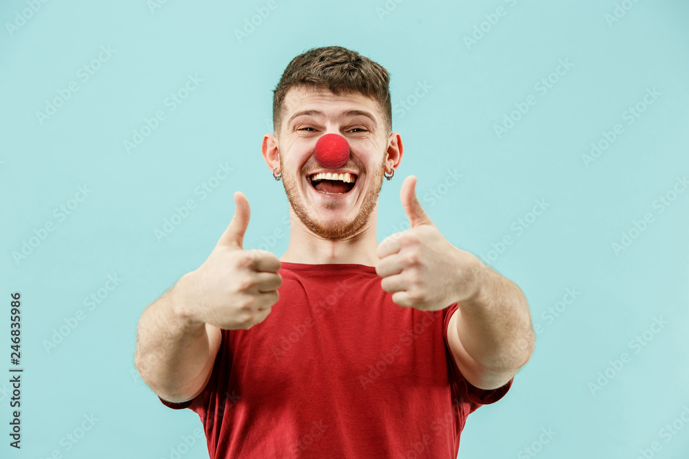 The happy surprised and smiling man on red nose day. The clown, fun, party, celebration, funny, joy, holiday, humor concept The happy surprised and smiling man on red nose day. The clown, fun, party, celebration, funny, joy, holiday, humor concept