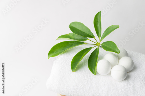 Handmade salt bath bombs in balls shape from organic vegan natural ingredients on white towel green house plants. Spa wellness body care wellbeing. Clean minimalist style