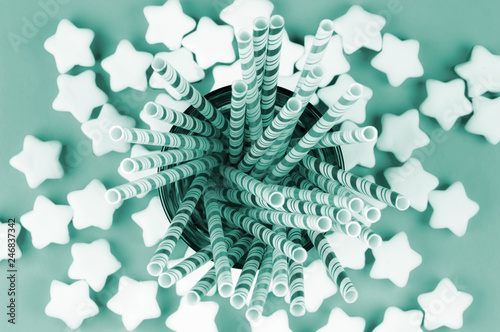 festive composition of marshmallow stars and cocktail straws in a glass, top view.