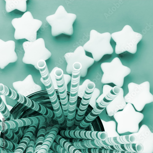  festive composition of marshmallow stars and cocktail straws in a glass, top view.