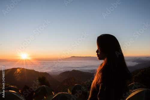 Happy woman wake up in morning on the mountain