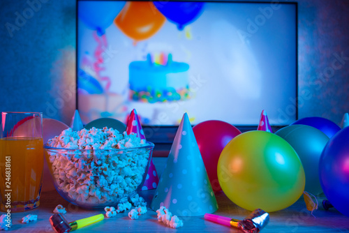 Popcorn birthday, party. On the background of TV and color bright light. Concept of festivals