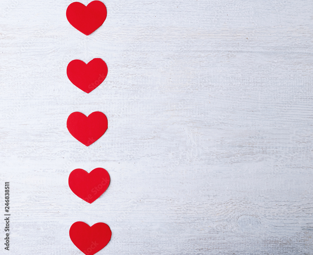 Red hearts on a white wooden background. Place for text, copy space