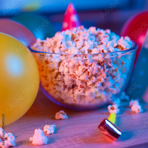 Popcorn birthday, party. On the background of TV and color bright light. Concept of festivals