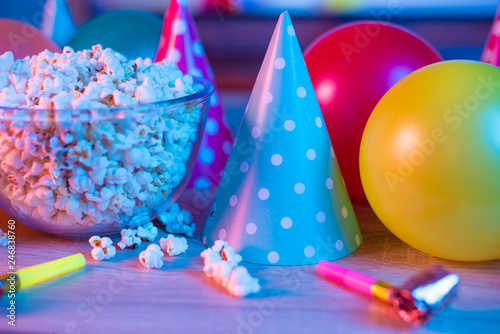 Popcorn birthday, party. On the background of TV and color bright light. Concept of festivals