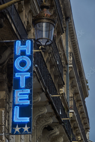 European Neon hotel sign with hotel in the background