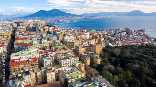 Aerial view of Naples from the Vomero district. You can see Castel Sant'elmo in the foreground while in the background the city's port, the Vesuvius and the Ovo castle. There are houses and buildings. photo