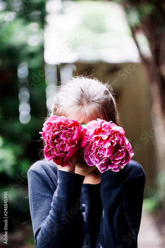 Young girl hading her face with flowers photo