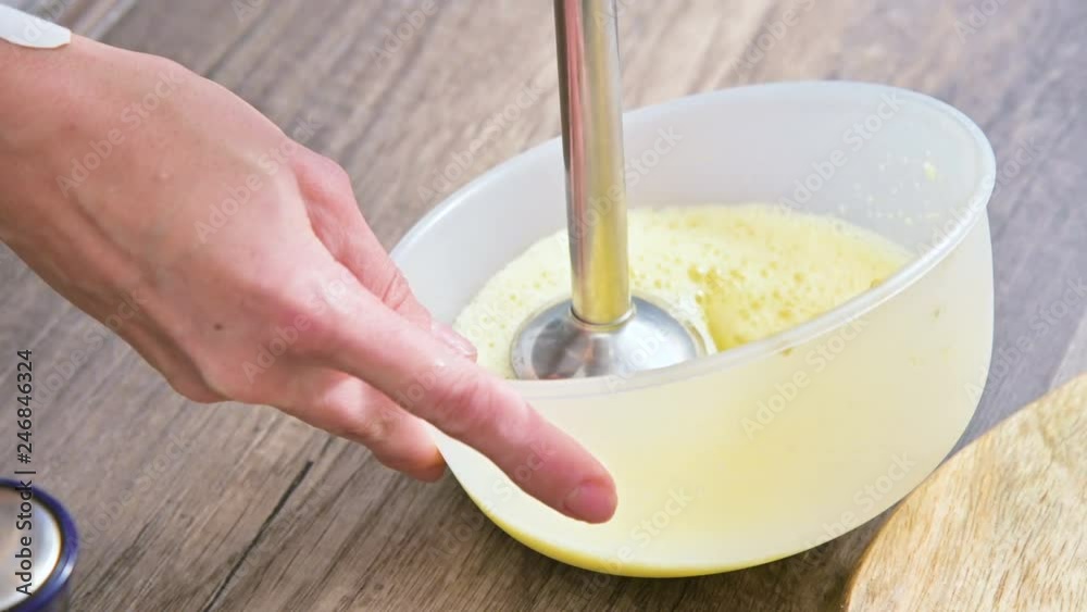 close-up whipping homemade mayonnaise with a blender in a plastic bowl close-up whipping homemade mayonnaise with a blender in a plastic bowl