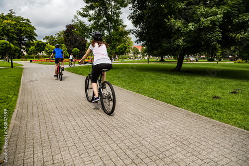 Healthy lifestyle - people riding bicycles in city park