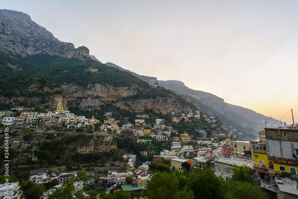 View on a city in mountains near coast. Town at the sea at dusk or night