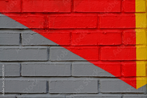 Colorful (yellow, grey and red) brick wall as background, texture