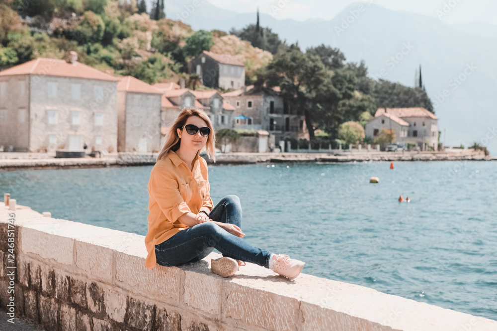 life style. travel and freedom. A girl in the background of the mountains of Montenegro sits in the old town by the sea.
