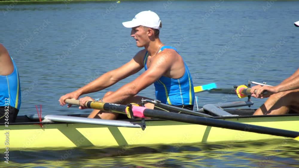 Rowing team summer training. 8 athletes rowers in a boat in the river Dnipro. City area in Kiev, Ukraine