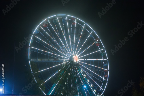 Ferris wheel at the amusement park, night illumination