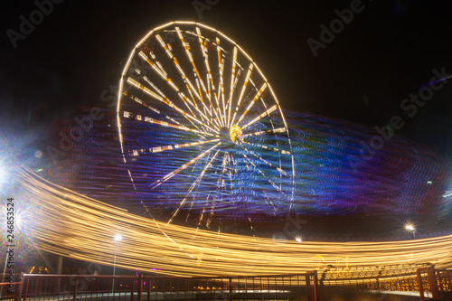 Ferris wheel in motion at the amusement park  night illumination. Long exposure
