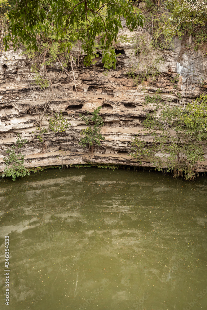 Sacrificial Cenote in Mayan Chichet Itza ruins. This deep water hole was used by ancient Mayans to sacrifice newborn children Sacrificial Cenote in Mayan Chichet Itza ruins. This deep water hole was used by ancient Mayans to sacrifice newborn children