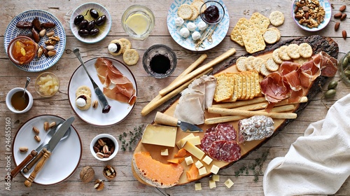 Appetizers table with various of cheese, curred meat, sausage, olives and nuts Festive family or party snack concept. Overhead view. photo