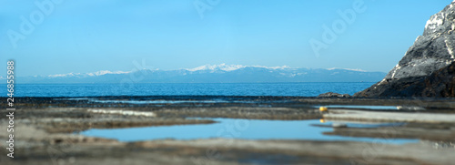 Reflective sky in water at pier and snowly mountains