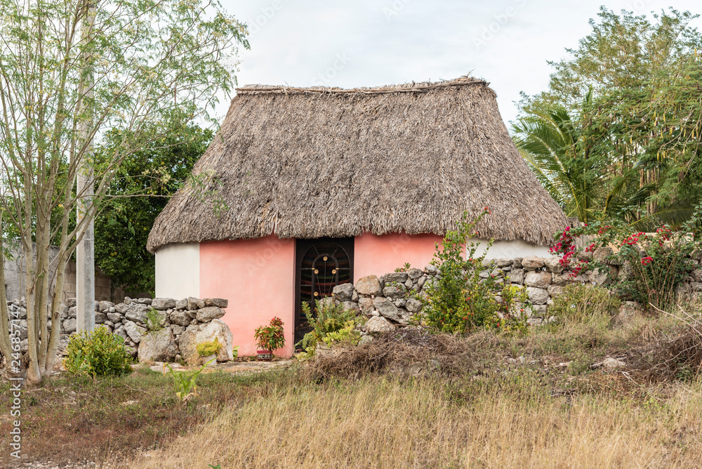 Traditional Mayan palm rooftop house in Yucatan, Mexico. This is the traditional house or hut used to live by the people in Mexico's Yucatan peninsula Traditional Mayan palm rooftop house in Yucatan, Mexico. This is the traditional house or hut used to live by the people in Mexico's Yucatan peninsula
