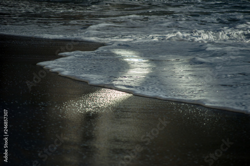 sea wave on a black pebble like a iceland beach with reflection light