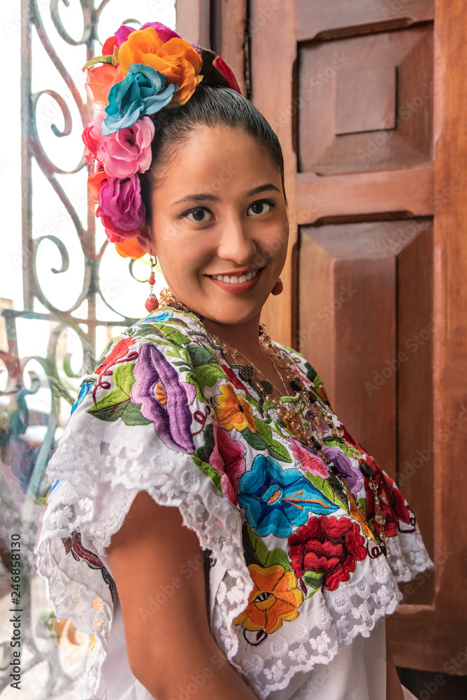 Pretty and colorful Mayan girl in Yucatan. Young smiling girl inviting tourism to visit Merida in the Yucatan peninsula