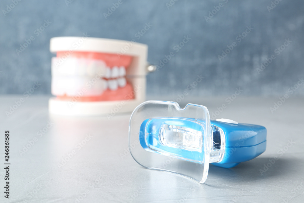 Teeth whitener on table against blurred background. Space for text