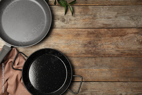 Flat lay composition with clean cookware and space for text on wooden background