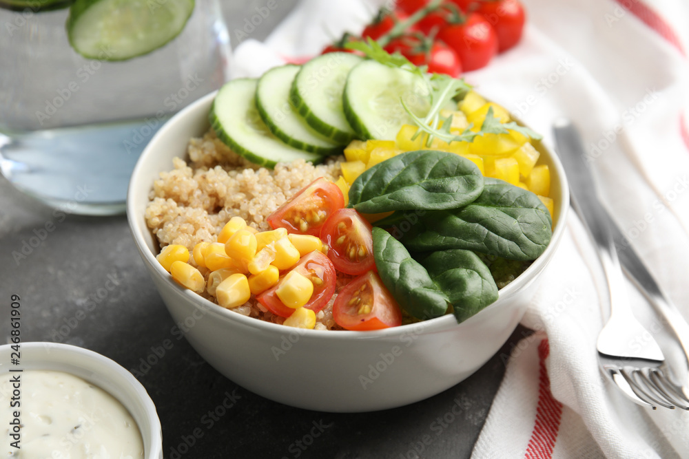 Healthy quinoa salad with vegetables in bowl on table, closeup