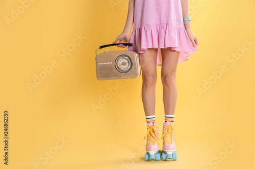 Young woman with roller skates and retro radio on color background, closeup. Space for text