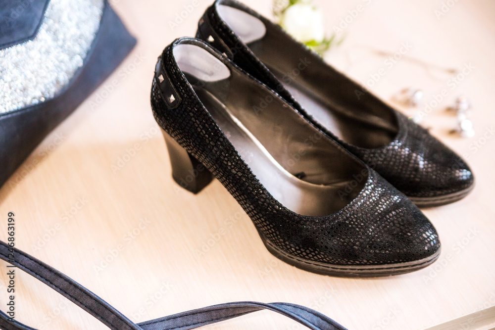 Naklejka premium Women's shoes and handbag on a wooden surface