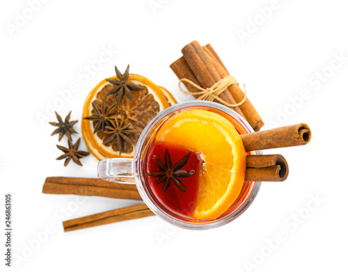 Glass cup of mulled wine, cinnamon and dried orange slices on white background, top view