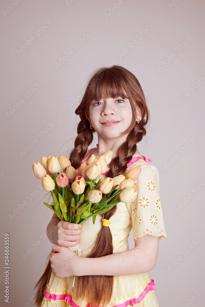 girl with a bouquet of flowers of tulips is standing, smiling, white background, is isolated. A gift to mom. mothers Day. women's Day. girl with a bouquet of flowers of tulips is standing, smiling, white background, is isolated. A gift to mom. mothers Day. women's Day.