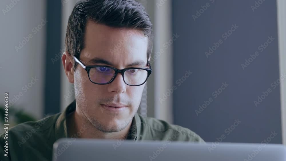 Young caucasian businessman typing on his laptop in a modern office Young caucasian businessman typing on his laptop in a modern office