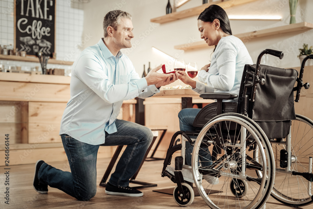 Handsome man proposing to woman in wheelchair Handsome man proposing to woman in wheelchair