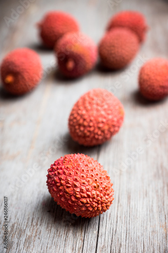 Red ripe lychees on the rustic background. Selective focus. Shallow depth of field.
