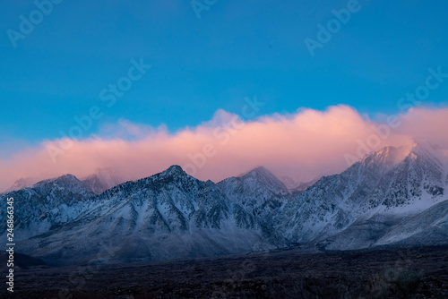 colorful cloudy morning sunrise sky over snowy mountain peaks of Sierra nevadas, California